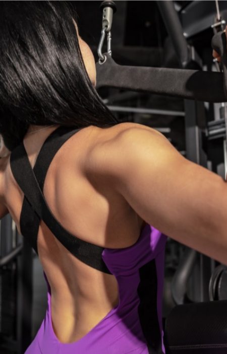 High. Young muscular caucasian woman practicing in gym with equipment. Athletic female model doing speed exercises, training her hands and chest, upper body. Wellness, healthy lifestyle, bodybuilding.