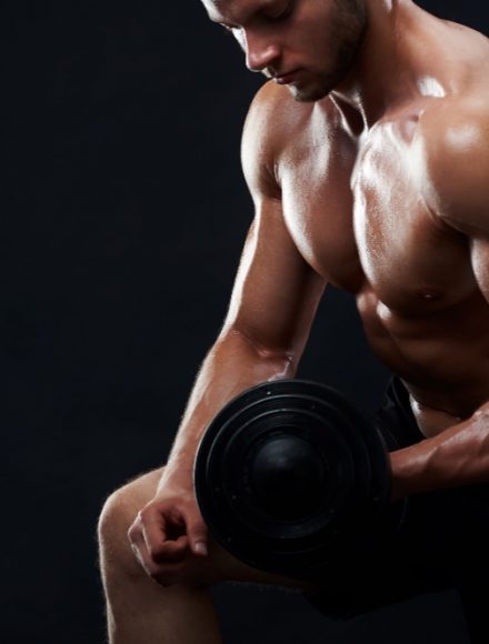 Cropped studio portrait of a handsome young muscular sportsman exercising shirtless showing off his strong sexy ripped body training with dumbbell on black background copyspace fitness gym motivation.